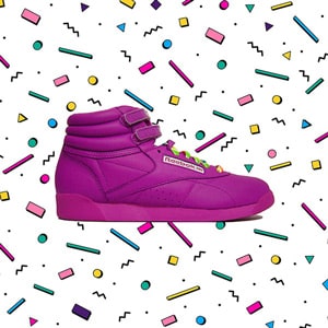 A Reebook pink shoe 80s style on an 80s pattern background