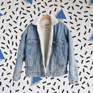 A shearling jacket in denim Levi's on an 80s pattern background